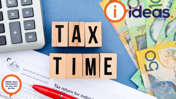 A background with calculator, Australian currency, Tax return form and pen. With the words "Tax Time" in black text on wooden blocks.