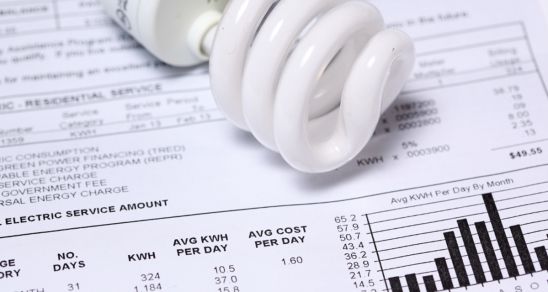 An image of a  lightbulb laying on a utility bill