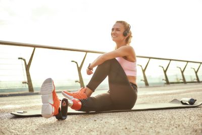 Image of a young woman with a disability on a yoga mat doing stretches