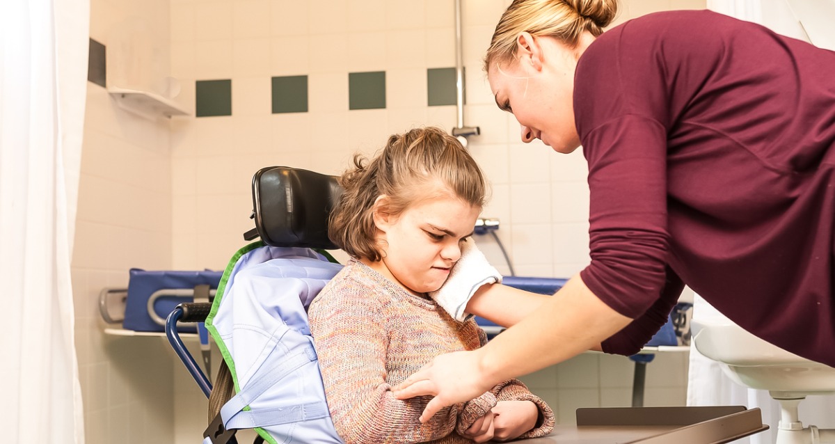 A care worker assisting a child with disability