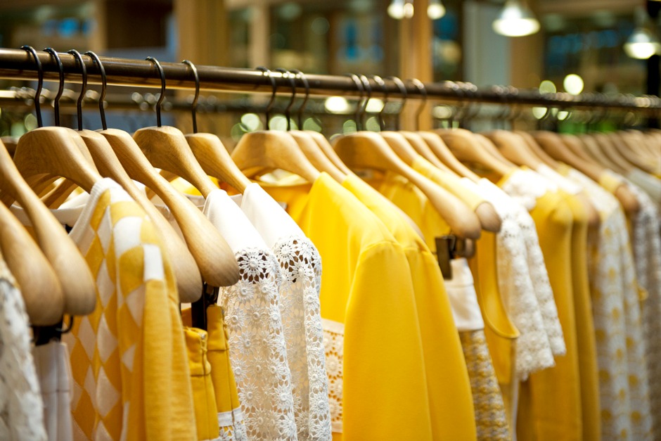 Row of sunshine coloured clothes on coat hangers h 