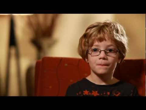 Young boy with glasses sitting in a chair