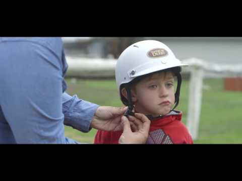 Person doing up a child's helmet