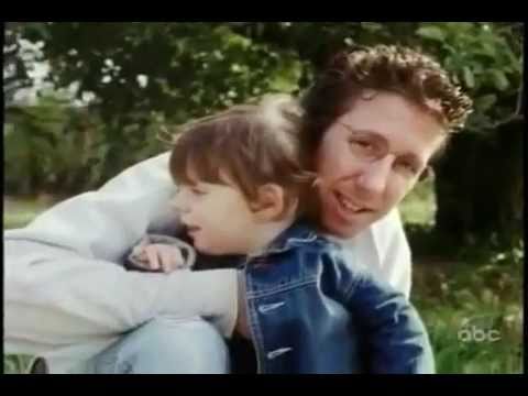 Man hugging a young girl outside