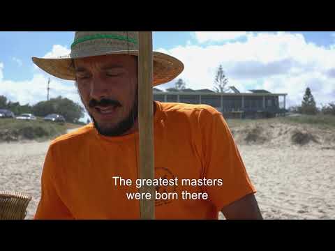 Man at the beach with a straw hat on