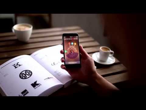 Persons hand holding mobile phone on a table with cups of coffee