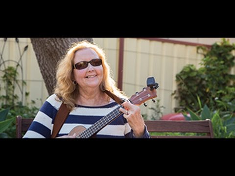 Lady standing outside playing a guitar 