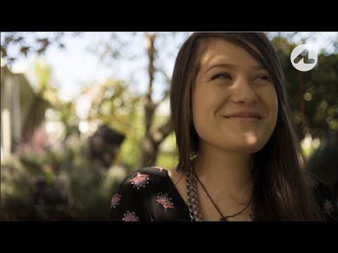 Young girl smiling sitting outside