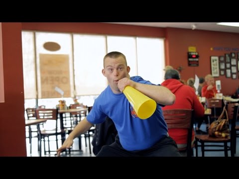 Man standing using a loud speaker in a restaurant 