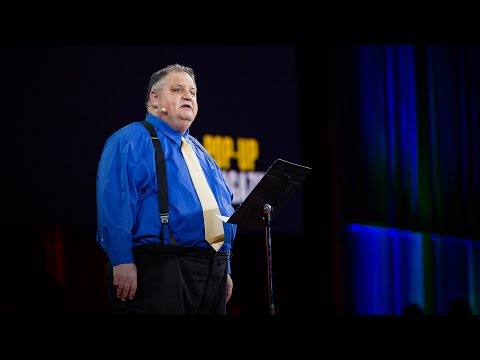 Man standing on stage with microphone speaking