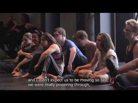 Group of people sitting on the floor of a dance studio