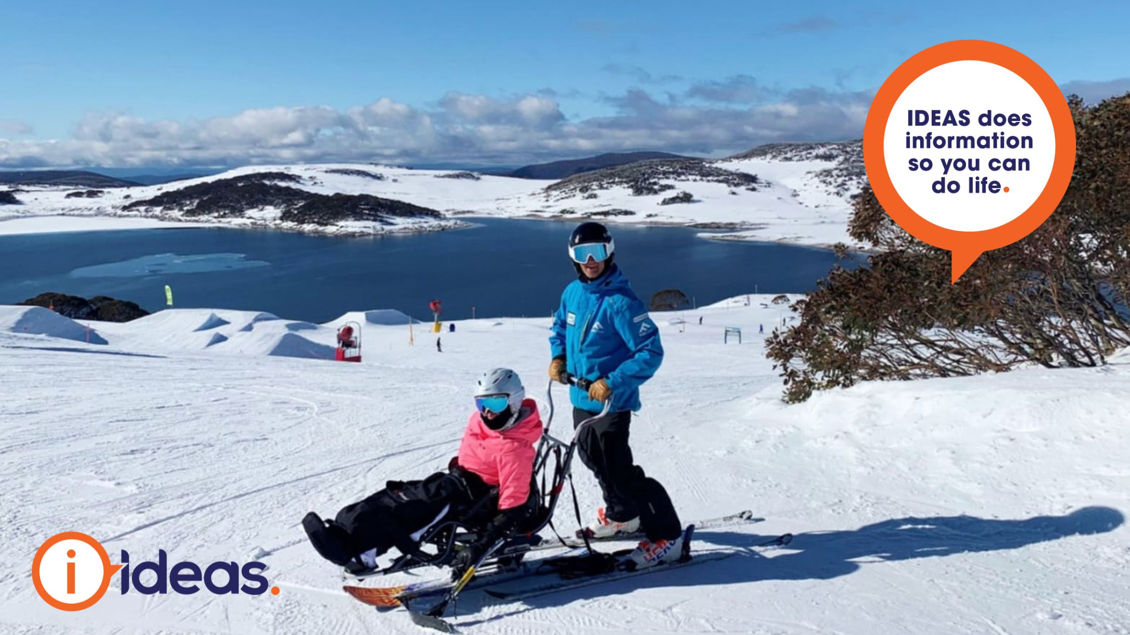 a person using a sit ski with a companion standing on skis behind