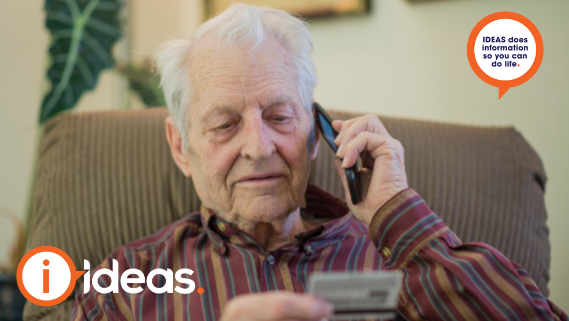 Elderly man on phone call holding credit card in hand