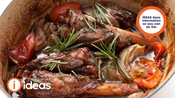 lamb shanks in a pot with sprigs of rosemary