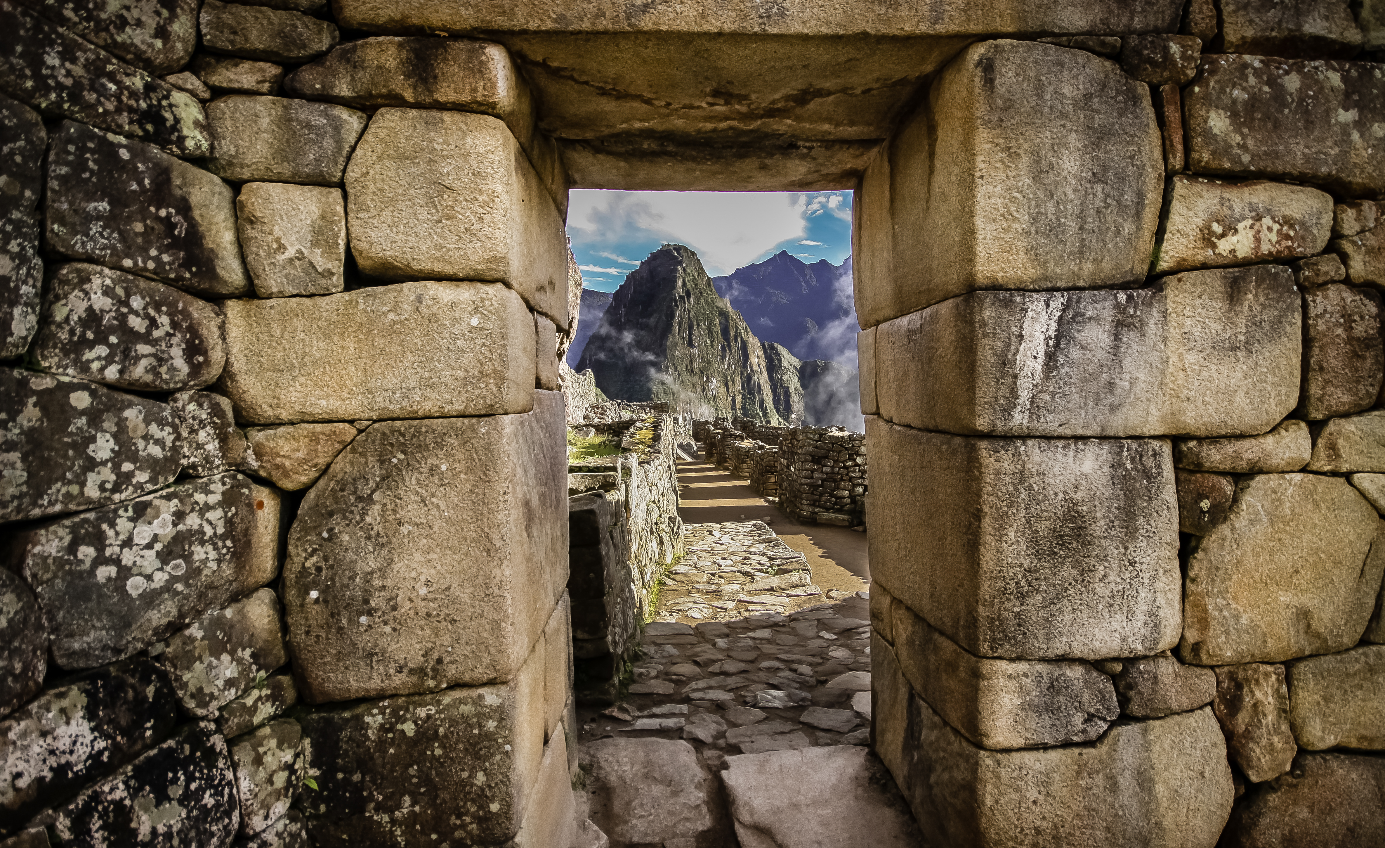 View of mountain peak through window in stone wall