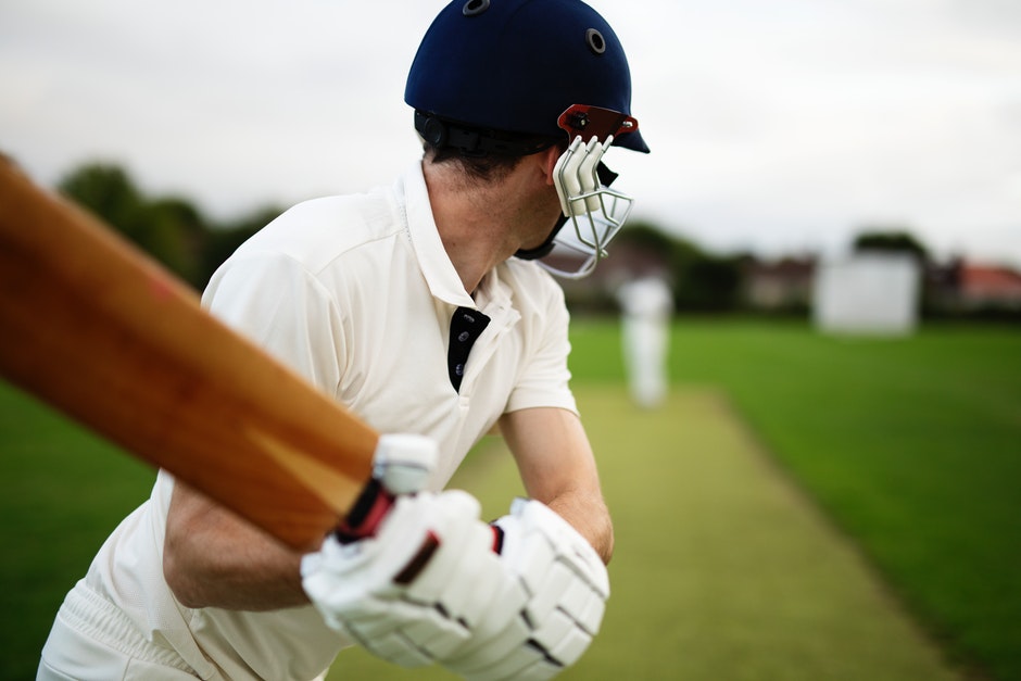 Image of cricket player with bat raised waiting for the ball