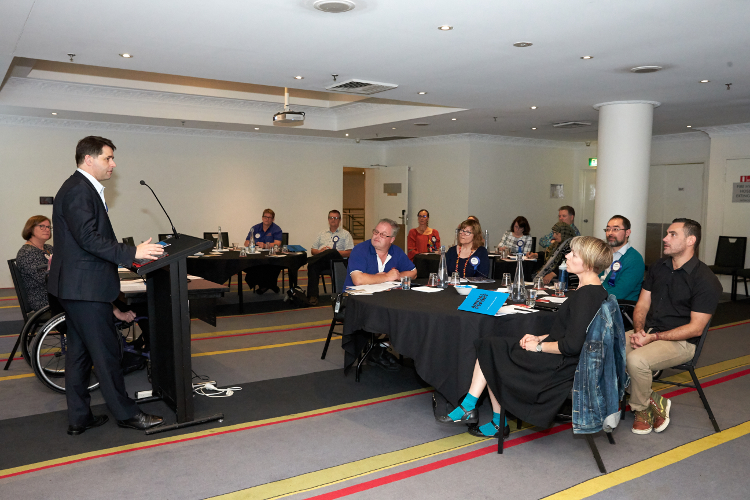 Image of Alastair McEwin speaking at IDEAS AGM with audience looking on