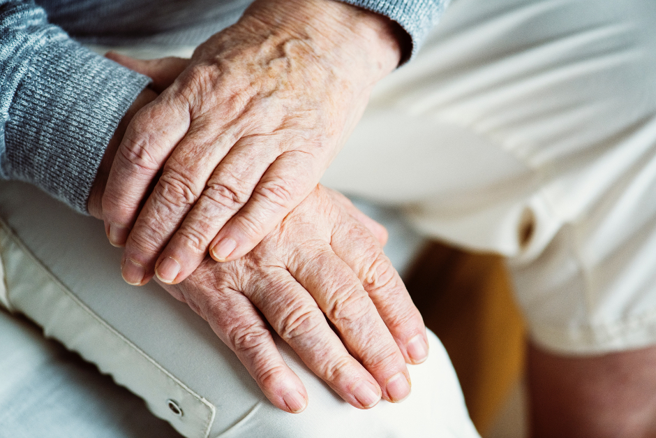 detail of older person holding hands in lap