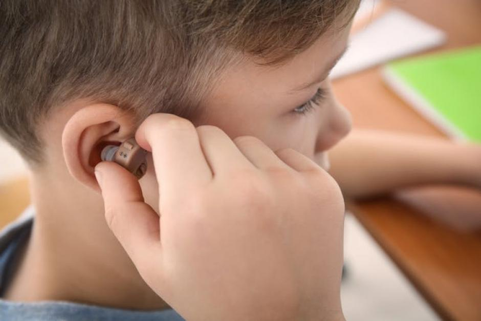 small boy with hearing aid