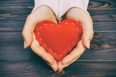 woman holding a stitched heart in her hands