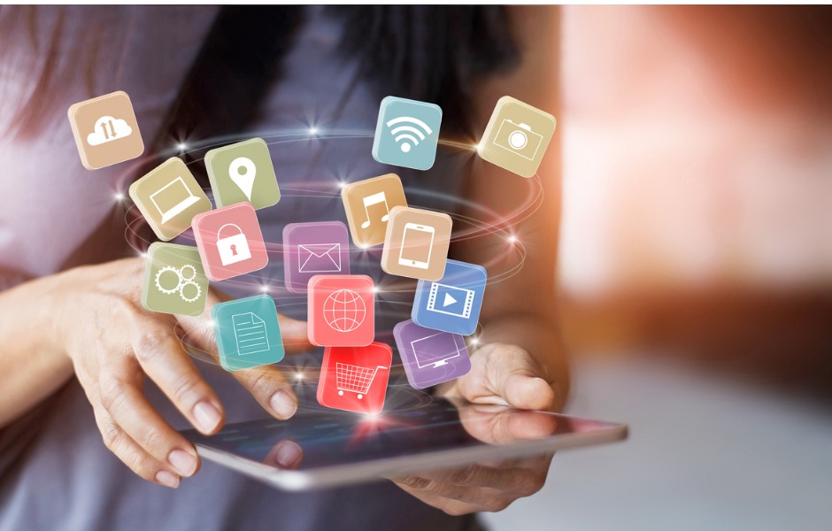 Woman using mobile device with apps floating in air above device