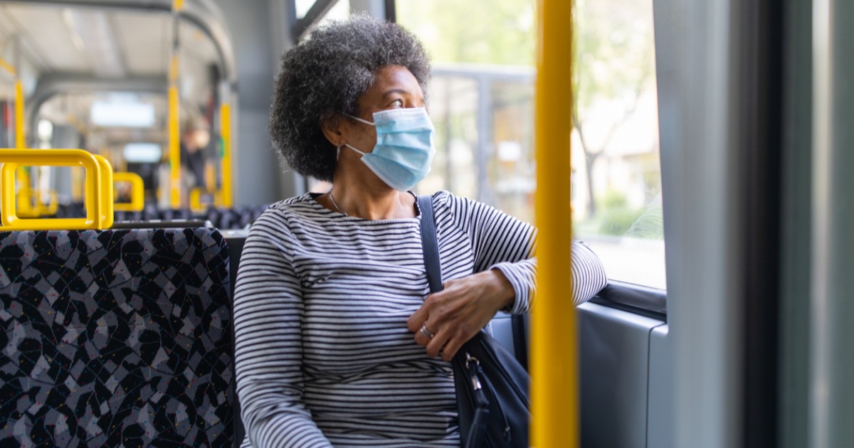 woman on bus wearing surgical face mask