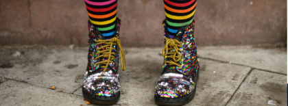 person wearing sparkle boots and rainbow socks.