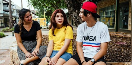 Image of three youths sitting and talking