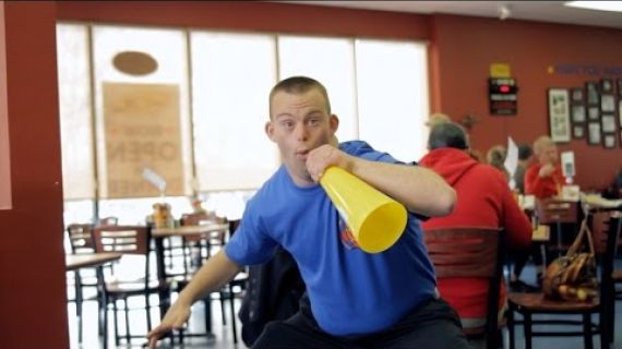 Man standing using a loud speaker in a restaurant