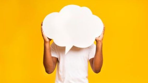 A person holding a white speech bubble in front of his face.