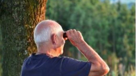 Man looking through a pair of binoculars