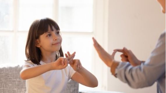 young girl and woman using sign language to communicate