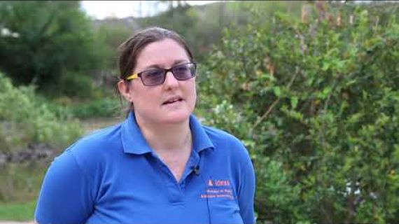 Woman standing in a garden with a microphone attached to her shirt