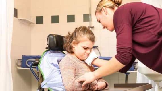 A care worker assisting a child with disability