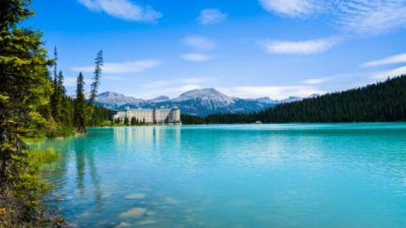 An image overlooking a blue lake with mountains in the background and Chateau Lake Louise