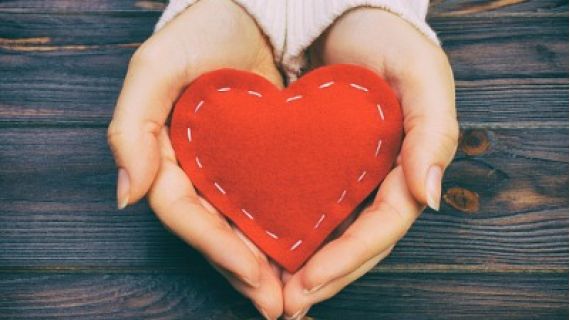 woman holding a stitched heart in her hands