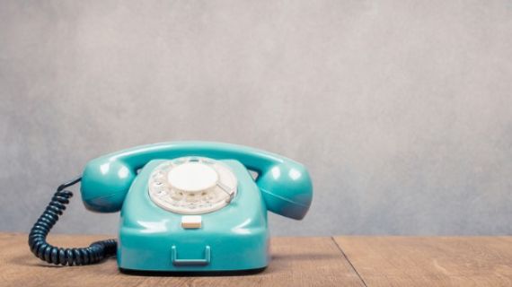 mint green rotary phone on a desk