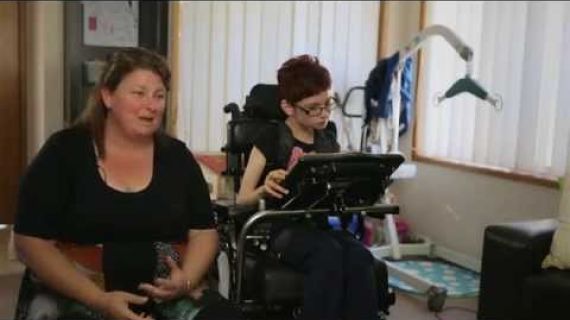 Lady girl in a wheelchair sitting next to her mum