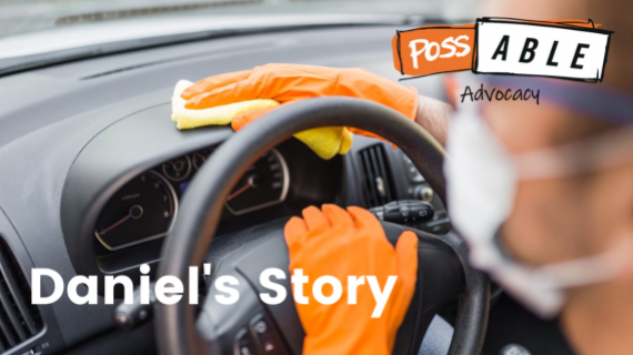 A man in medical face mask and orange gloves inside a car, cleaning it.