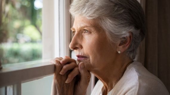 Elderly lady looking out a window