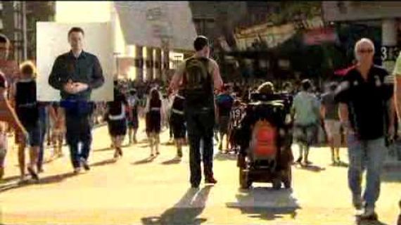 People walking on the footpath, man in a wheelchair with man walking beside him