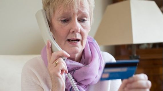 Elderly woman on phone call and holding credit card