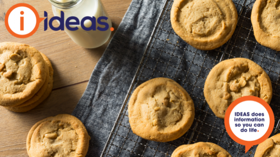 Cookies and a glass of milk laid on a cooling tray.