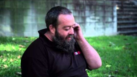 Man sitting on the grass talking on a mobile phone