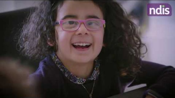 Young girl with pink glasses looking up and smiling