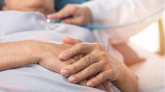 elderly woman in a hospital bed having a medical exam
