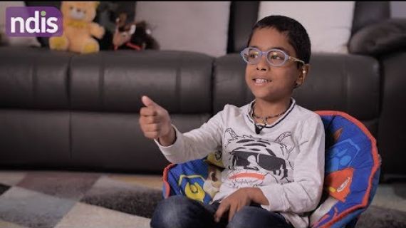 Boy sitting in chair in lounge room talking