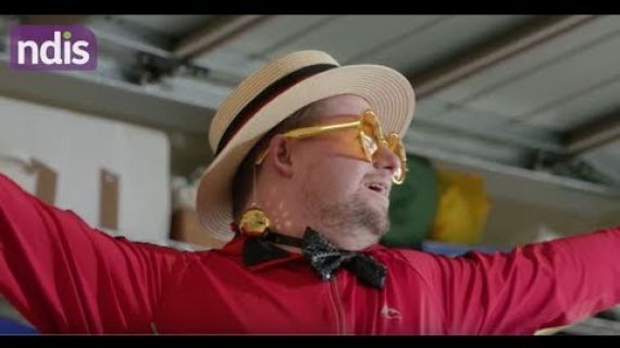Man with a hat and bright glasses on performing