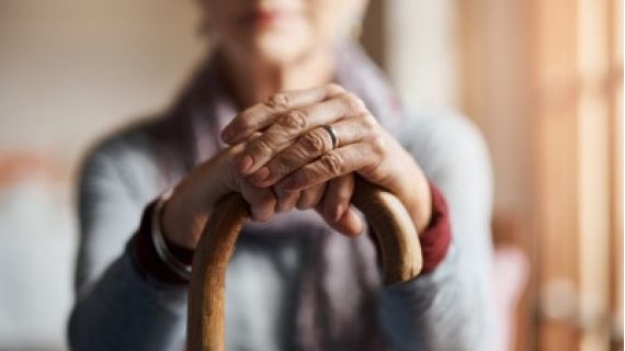 Older woman holding a cane.