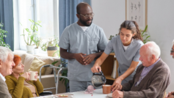 Group of elderly people at a table with 2 support workers